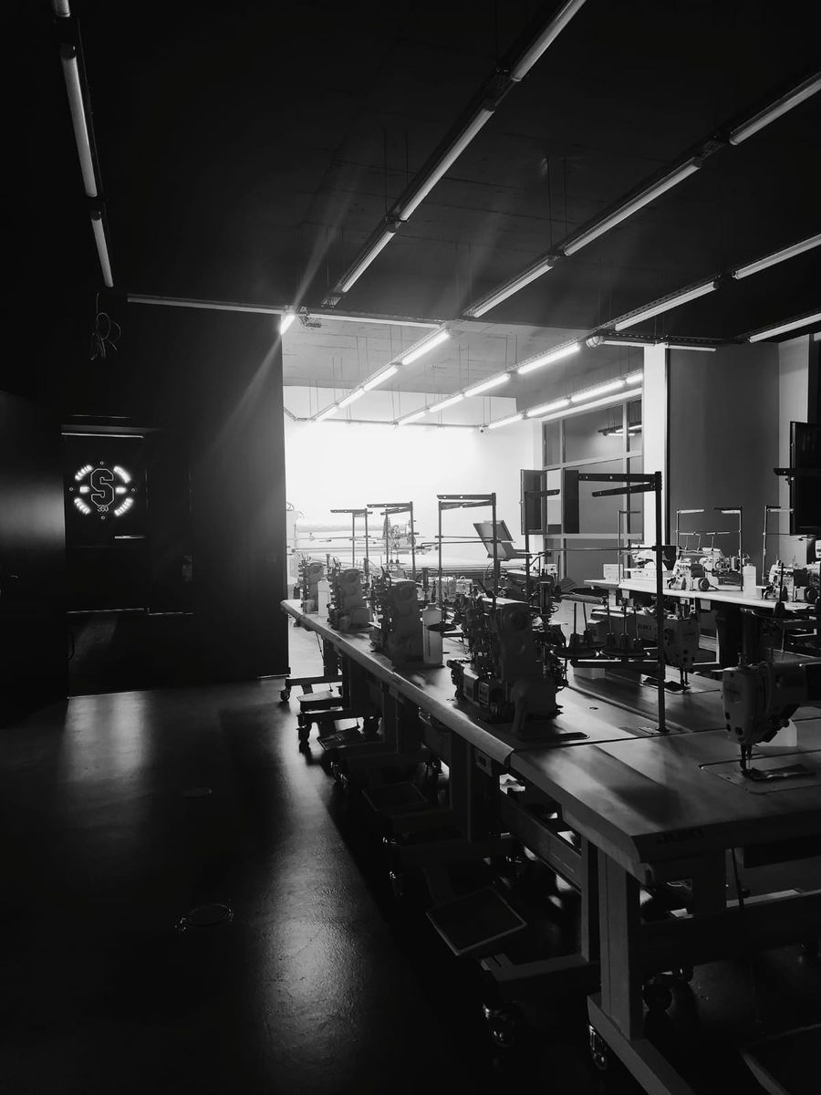Black and white view from a dark doorway onto the bright production floor