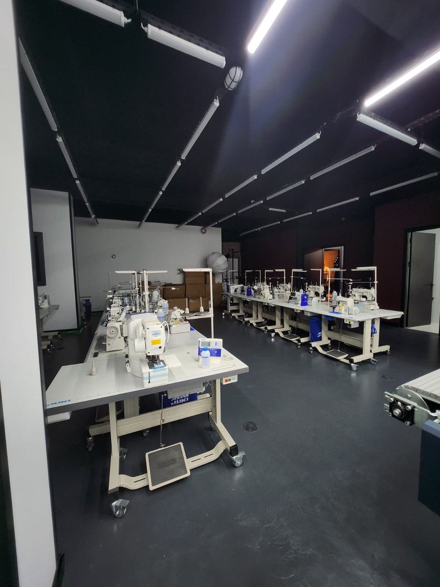 Sewing machines lined up under long ceiling lights