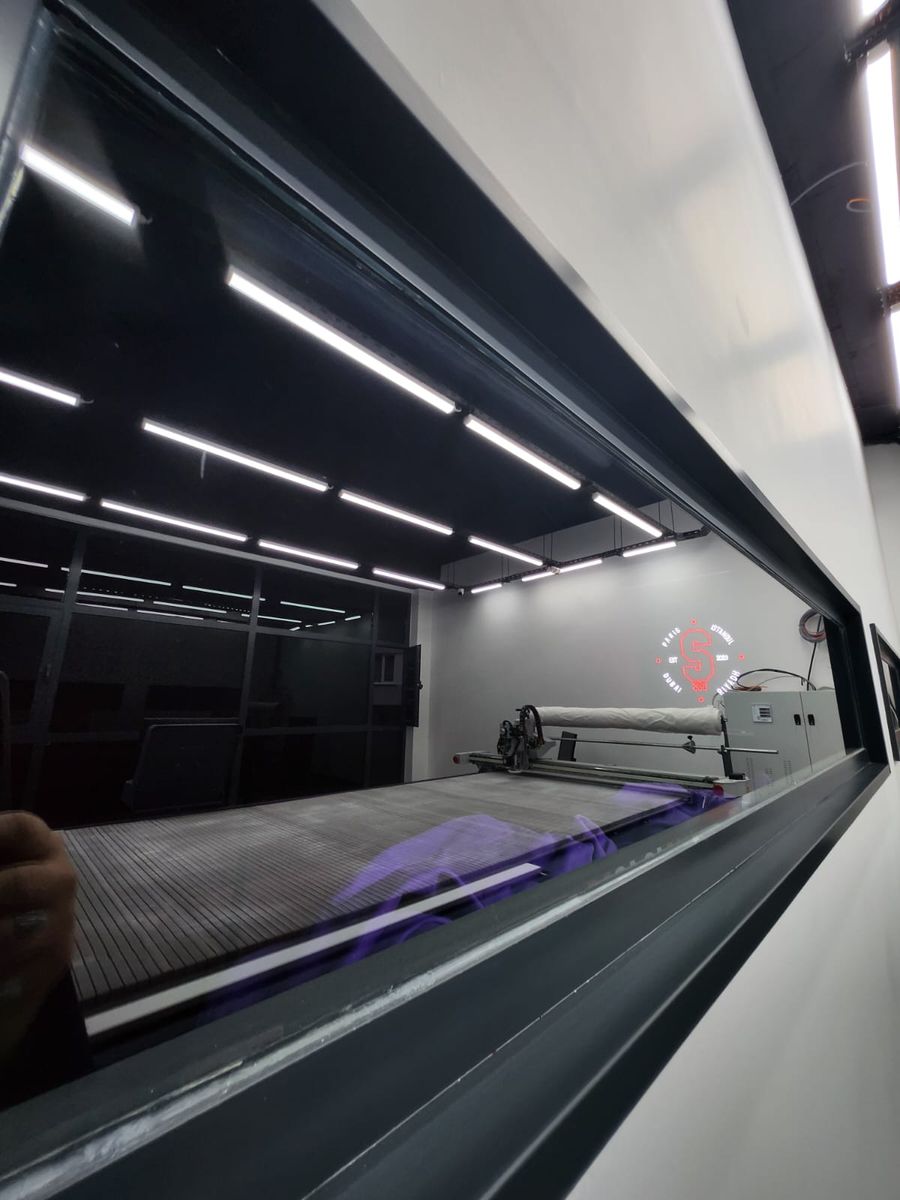 Long fabric spreading table seen through an interior window