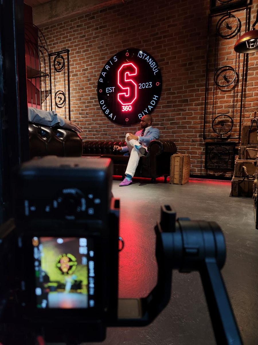 A camera on a gimbal framing the lounge and its neon sign