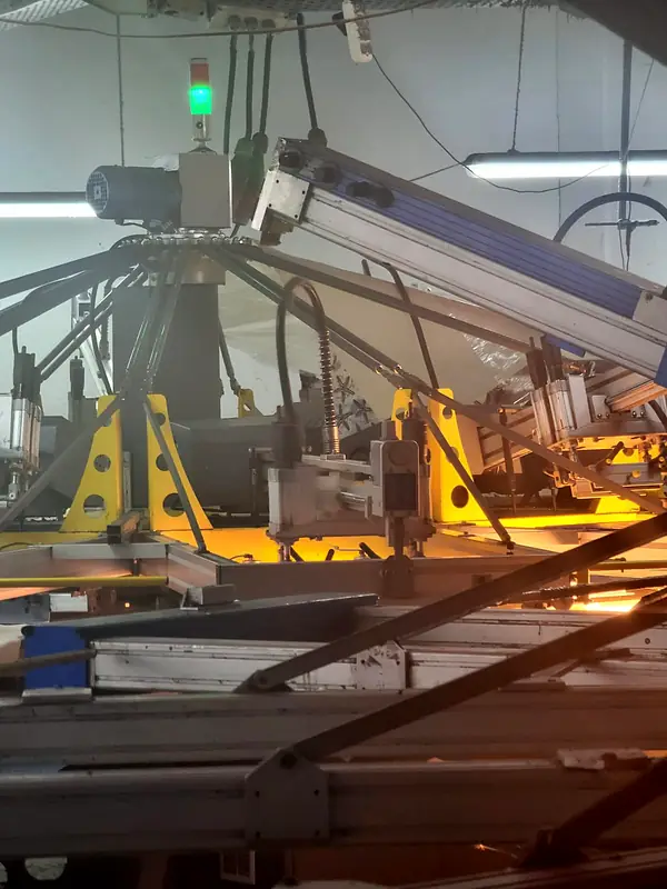 Automatic screen printing carousel glowing orange under the curing lamp