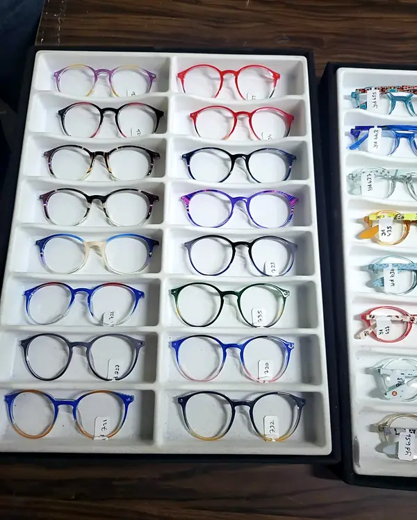 Tray of round glasses frames in gradient colours, each in its own slot