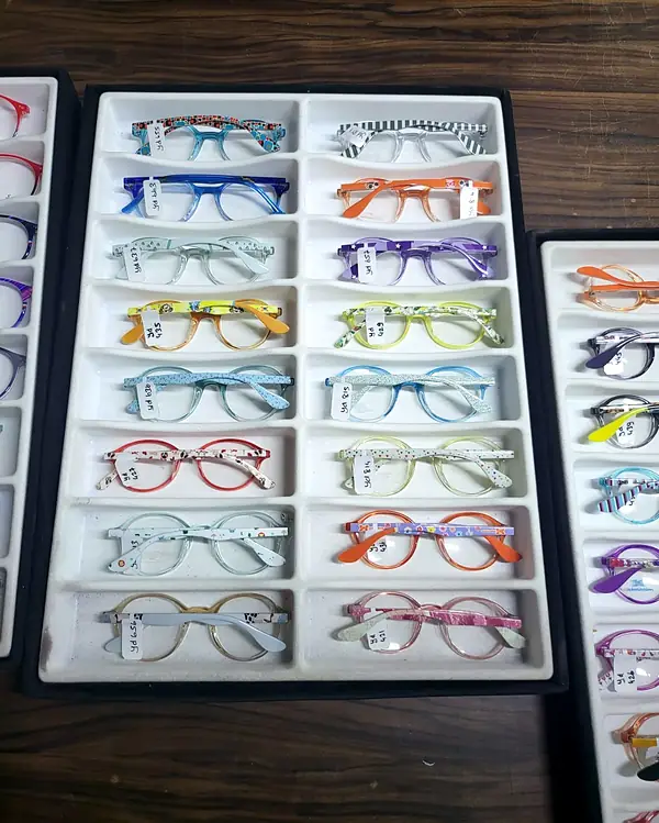Tray of colourful children's glasses with patterned arms