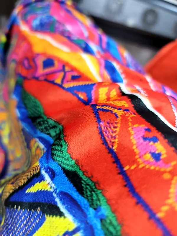 Close-up of fabric with a bright red, blue, green and pink print
