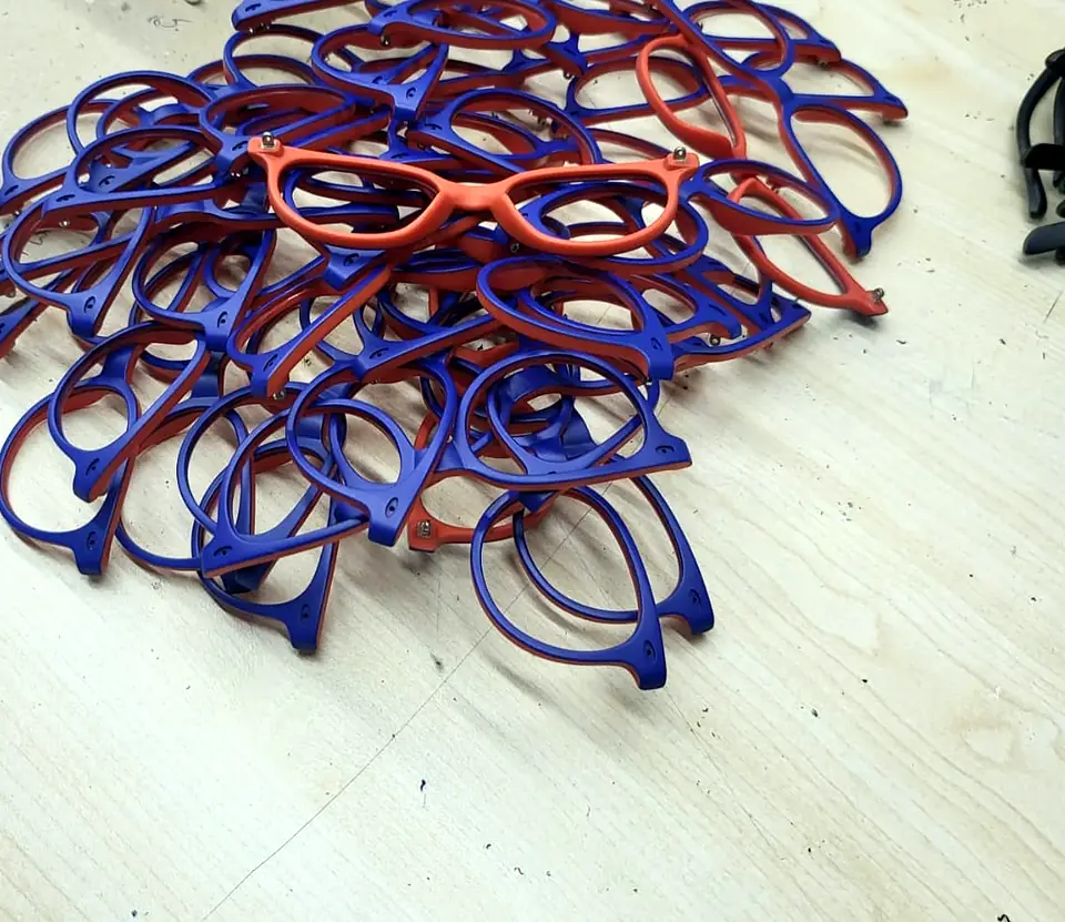 Pile of purple and coral glasses frames waiting for assembly