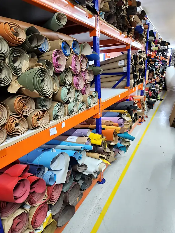 Long orange racks packed with rolled leather hides in every colour