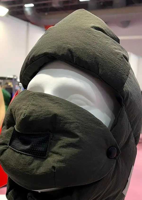 Olive padded hood with a snap-on face guard, on a white mannequin head