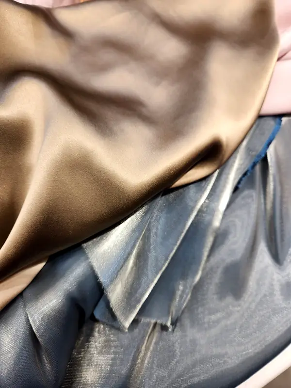 Champagne satin draped over a blue metallic lamé