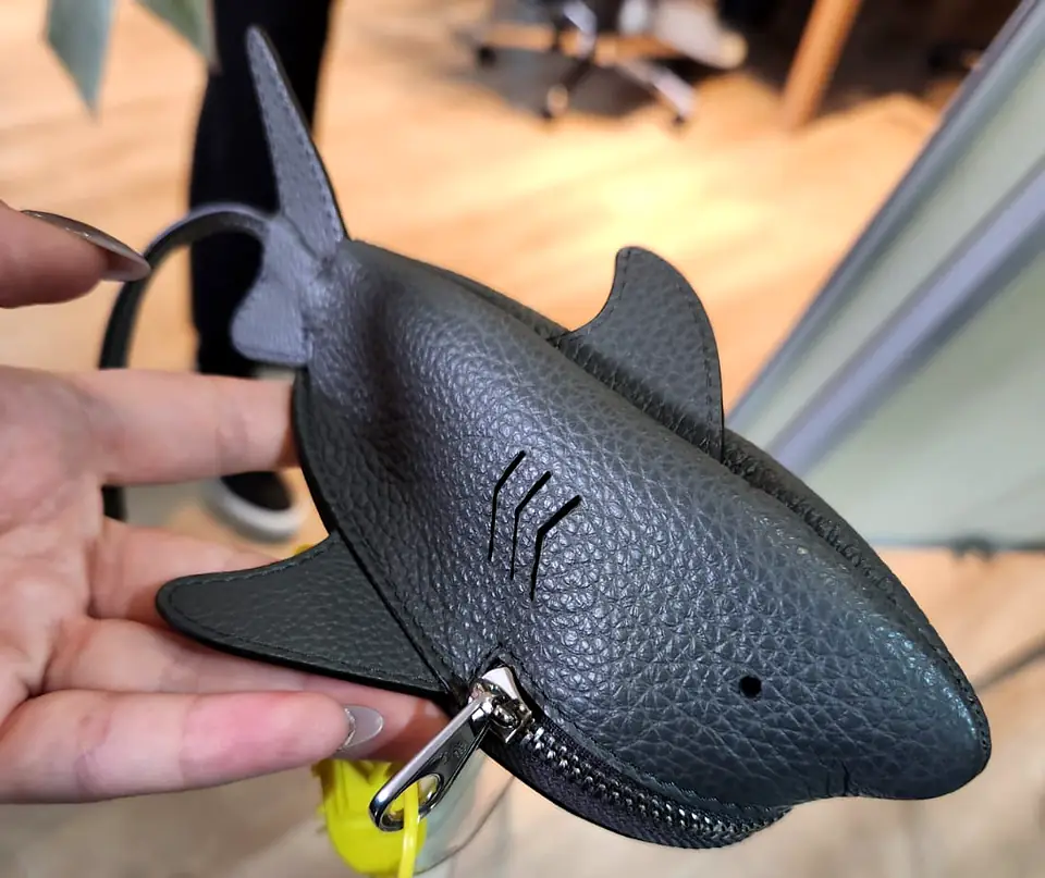 Dark grey leather coin pouch shaped like a shark, its zip forming the mouth